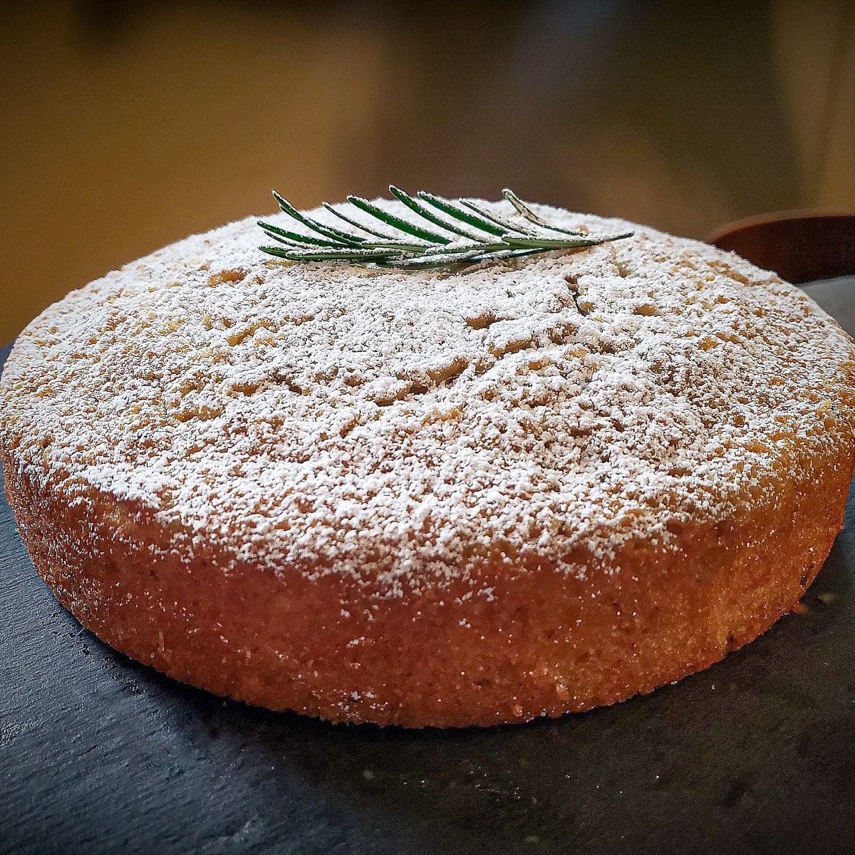 rosemary olive oil cake topped with rosemary