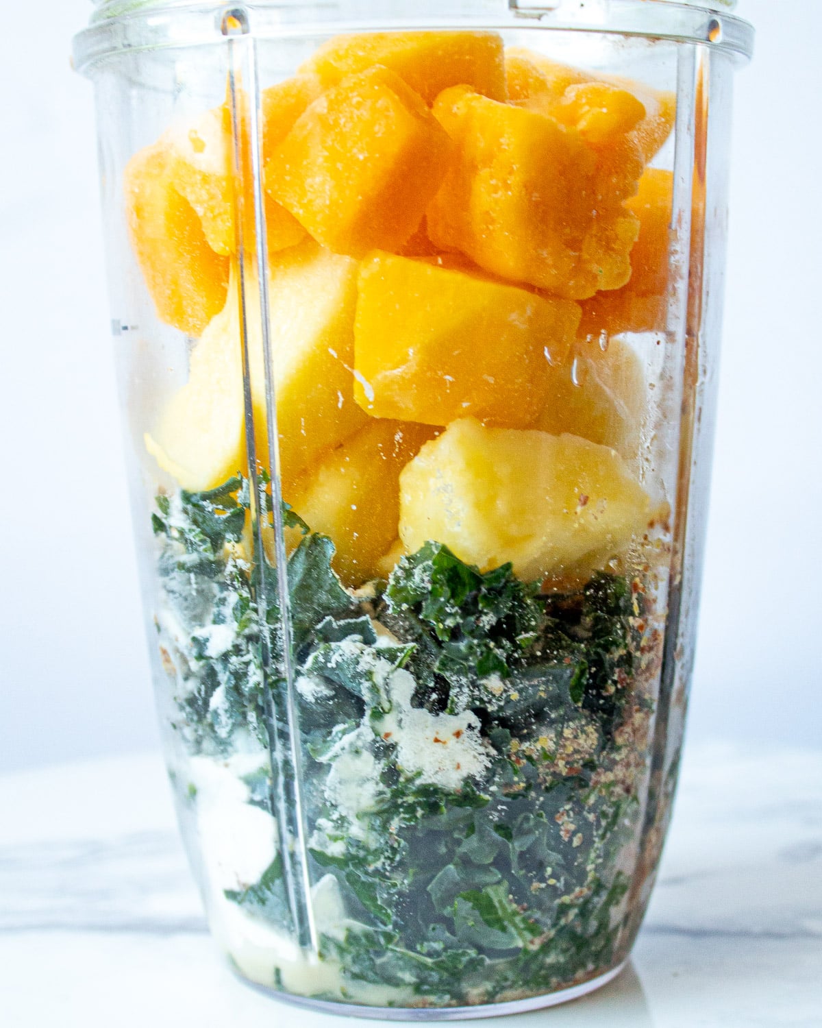 mango kale smoothie in a blender cup