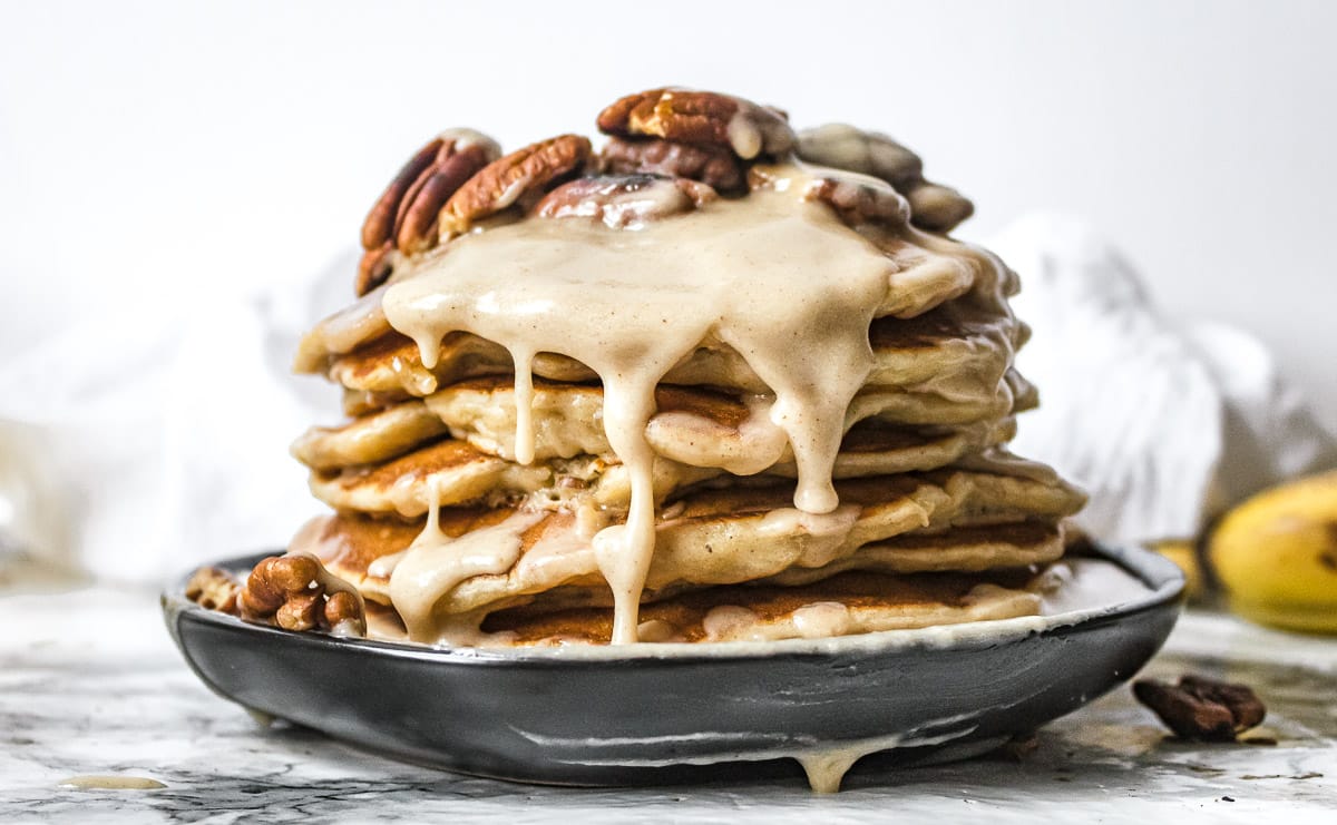 brown butter glaze and pecans on a stack of banana pancakes
