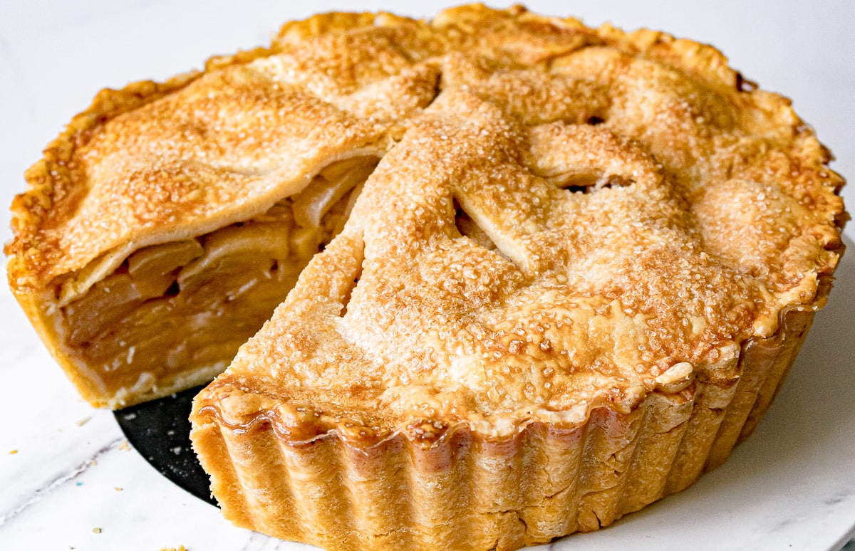 whole deep dish caramel apple pie with a slice cut out