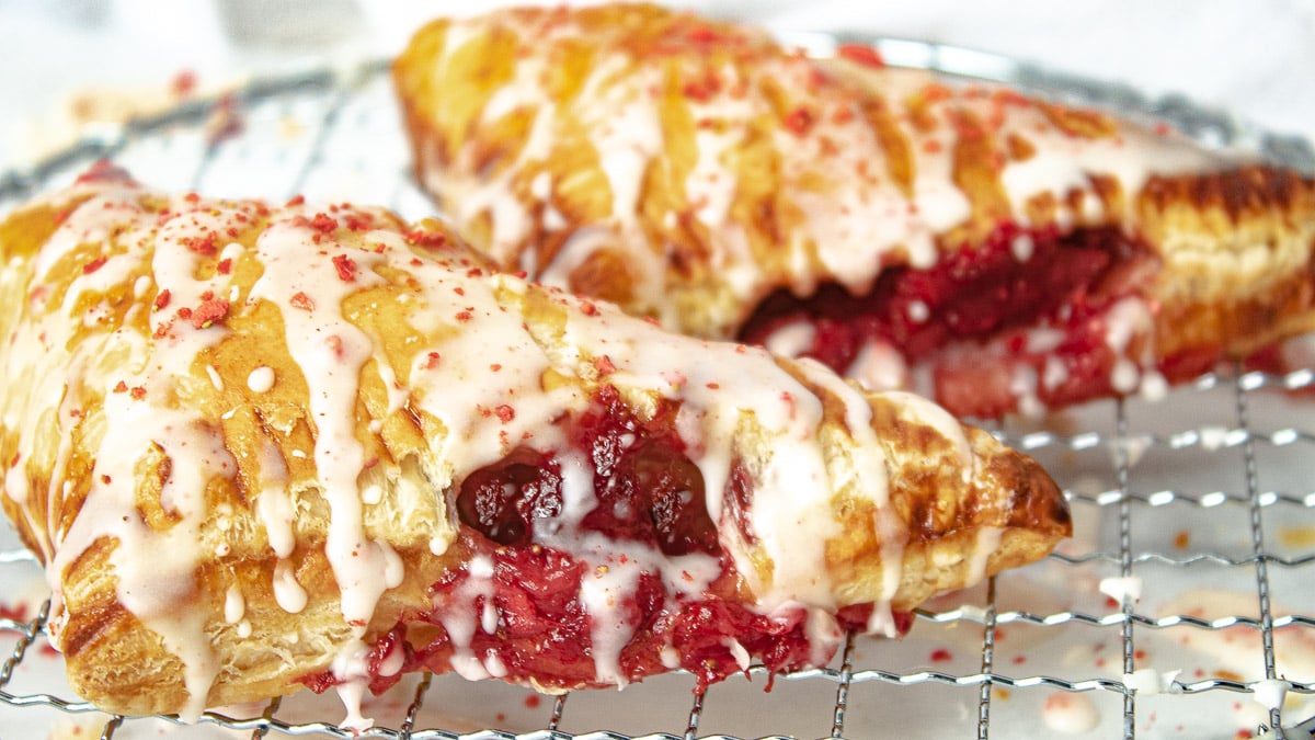 iced strawberry turnovers on a rack