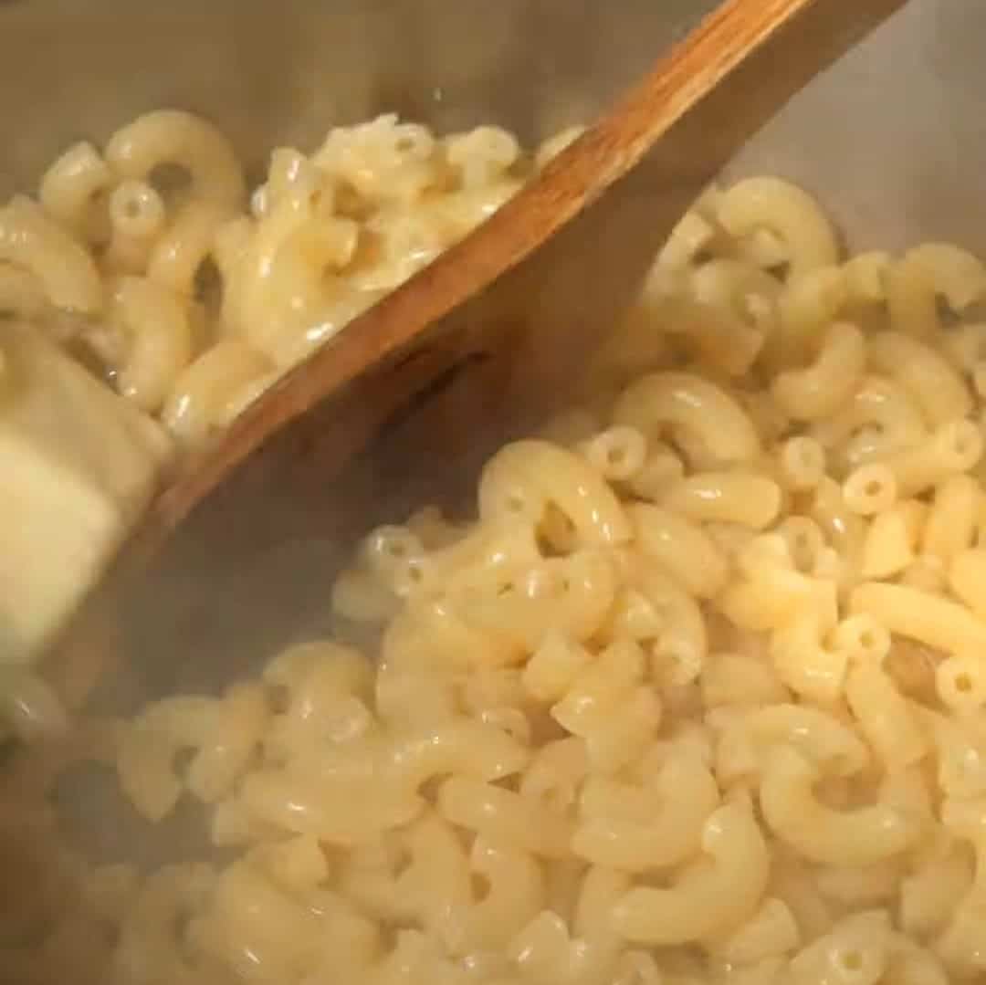 Stirring macaroni for southern style soul food mac and cheese recipe