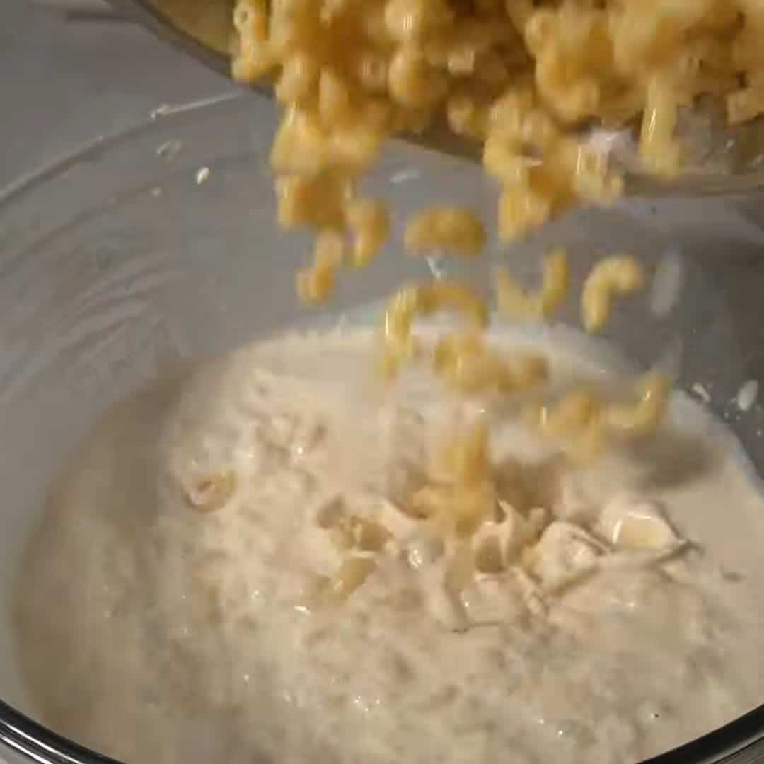 Mixing in cooked macaroni for southern style mac and cheese recipe.