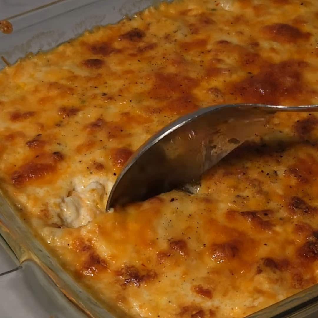 Spoon cutting into baked macaroni recipe.