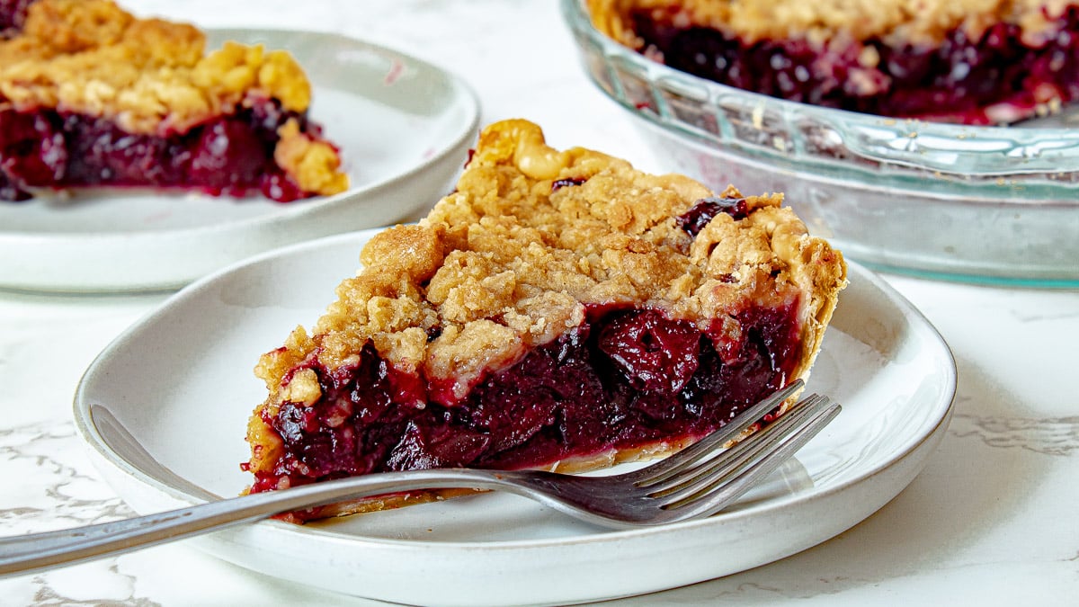 cherry crumb pie on a plate with a fork