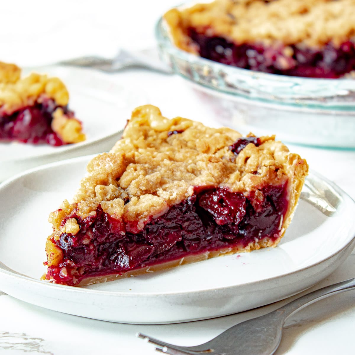 cherry crumb pie on a plate with a fork