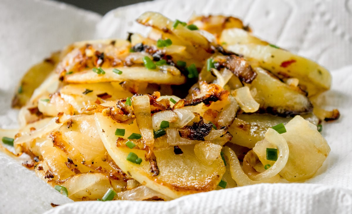 fried potatoes and onions on a paper towel
