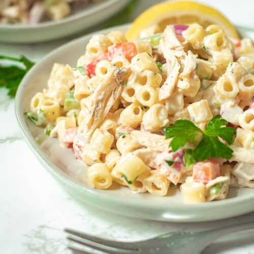 chicken macaroni salad on a plate with a lemon wedge