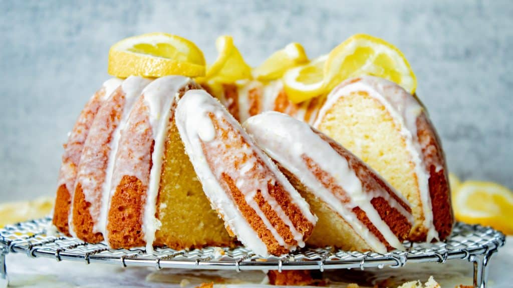 lemon sour cream pound cake on a wire rack with slices cut out