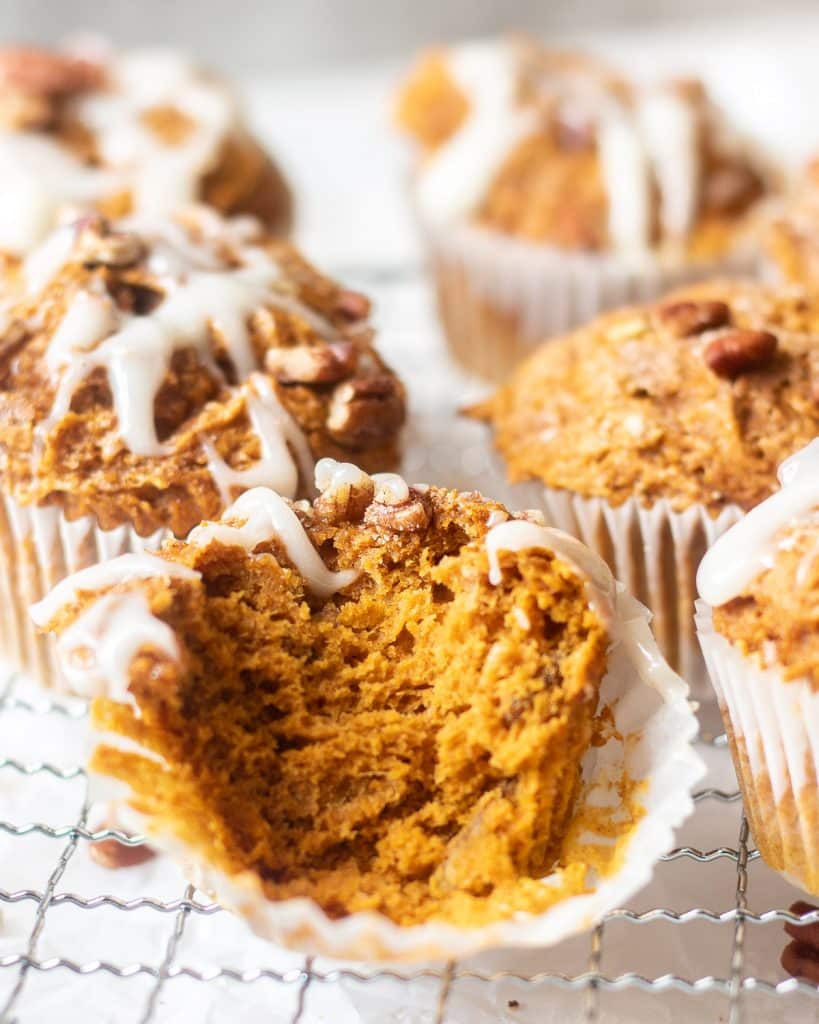 pumpkin muffins, one with a bite taken out of it