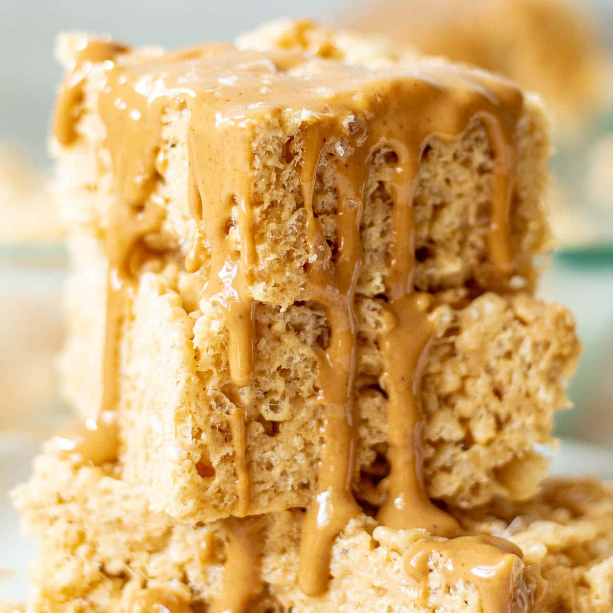 closeup of a stack of peanut butter rice krispie treats with melted peanut butter