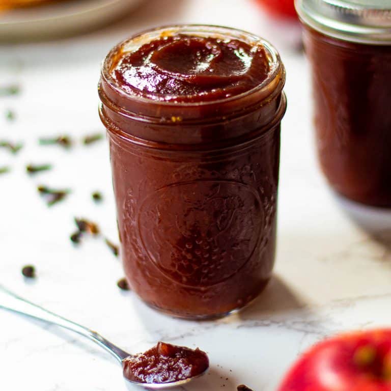instant pot apple butter in a jar with a spoonful next to it