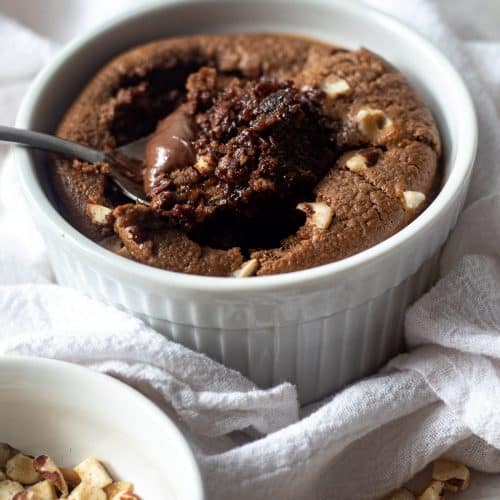 bowl of nutella baked oats with hazelnuts on top