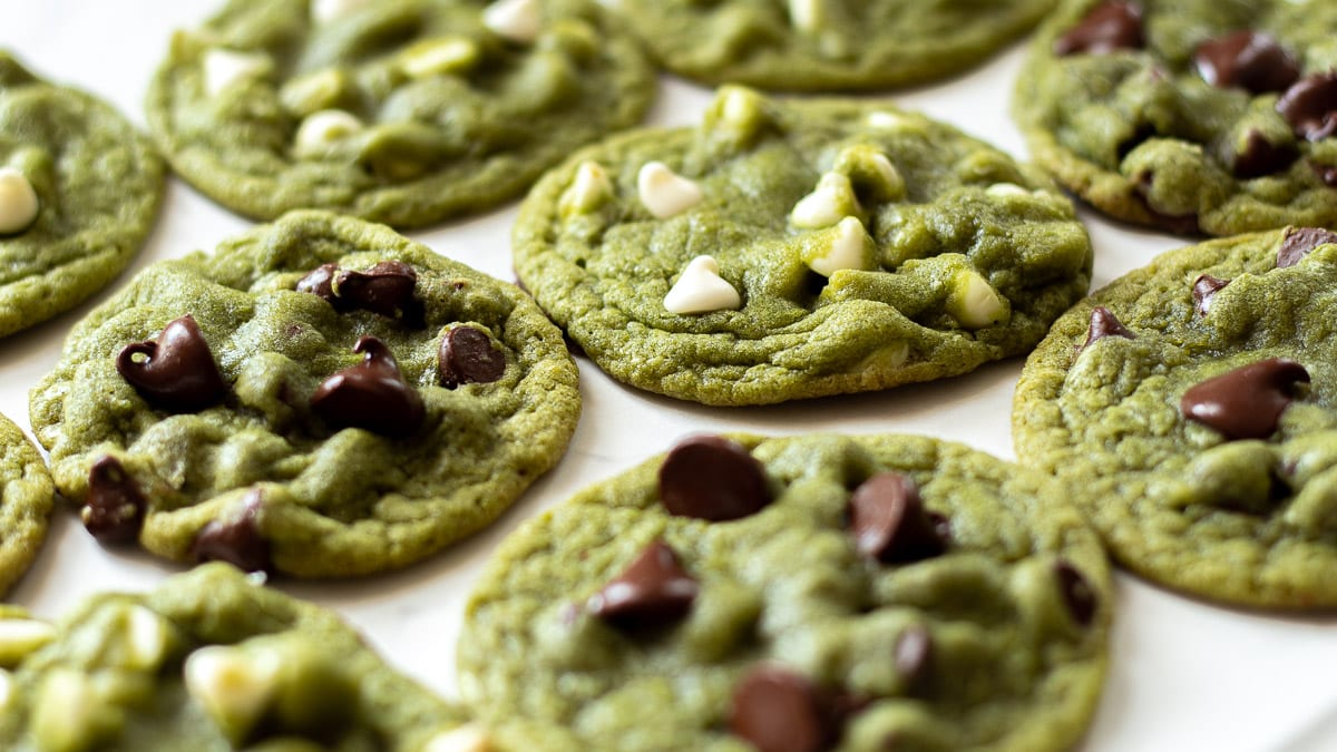 white and dark chocolate chips in matcha chocolate chip cookies on a tray