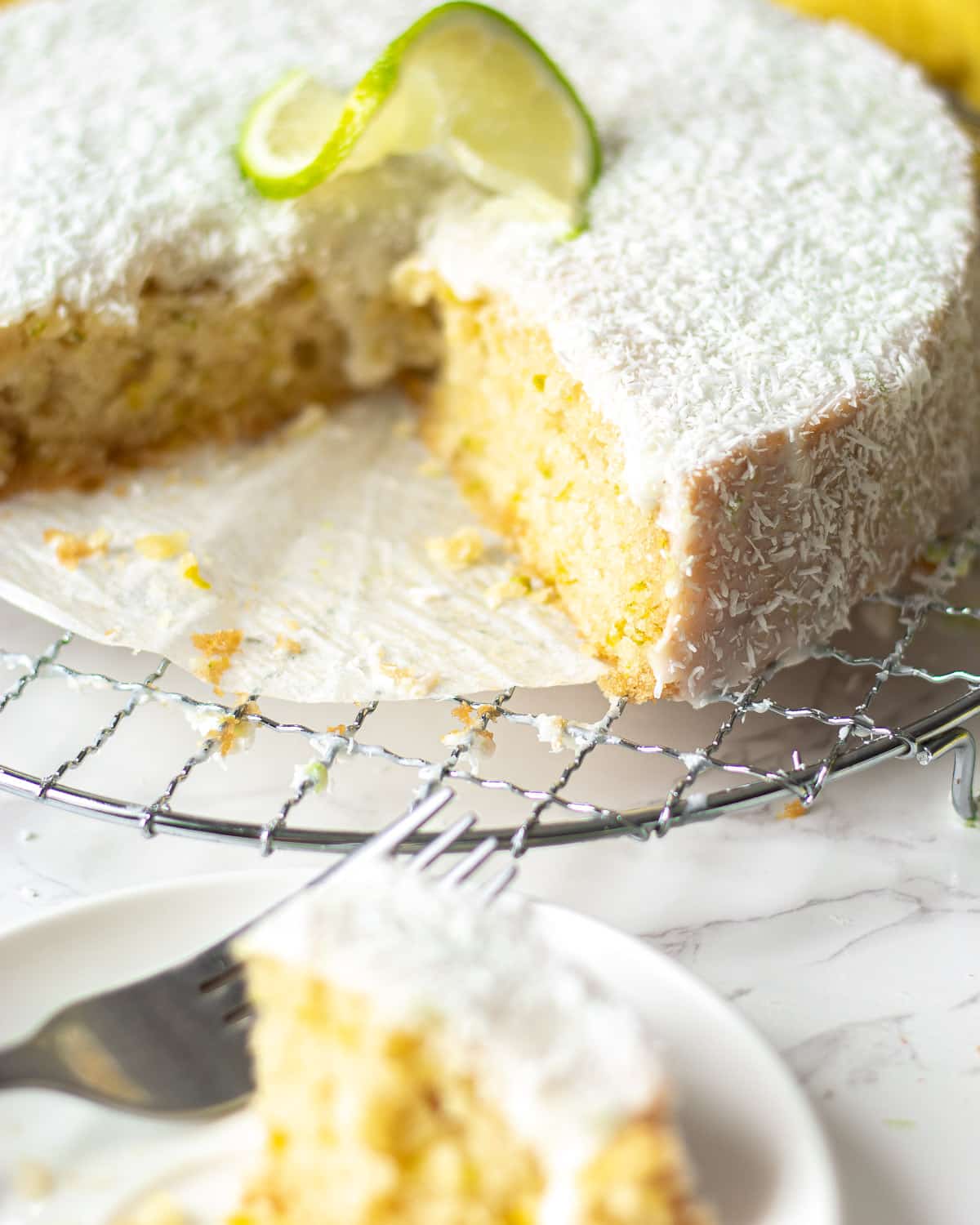 vegan coconut and lime cake with a piece cut out