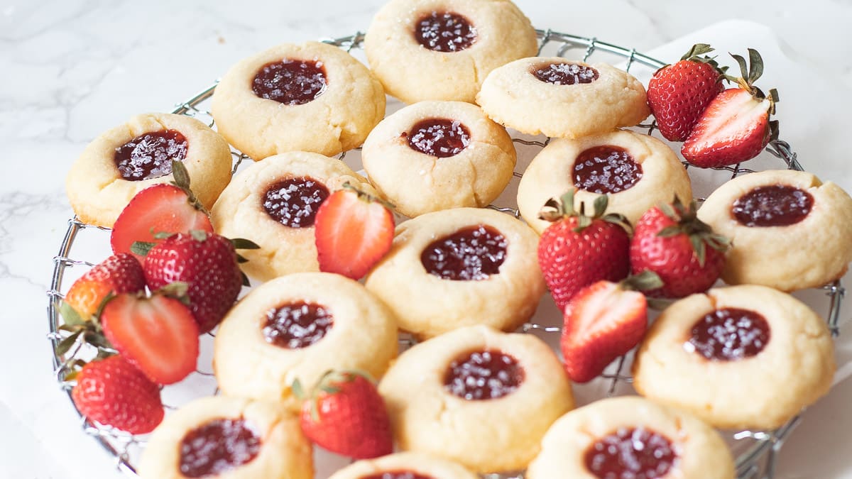 strawberry shortbread thumbprint cookies on a tray