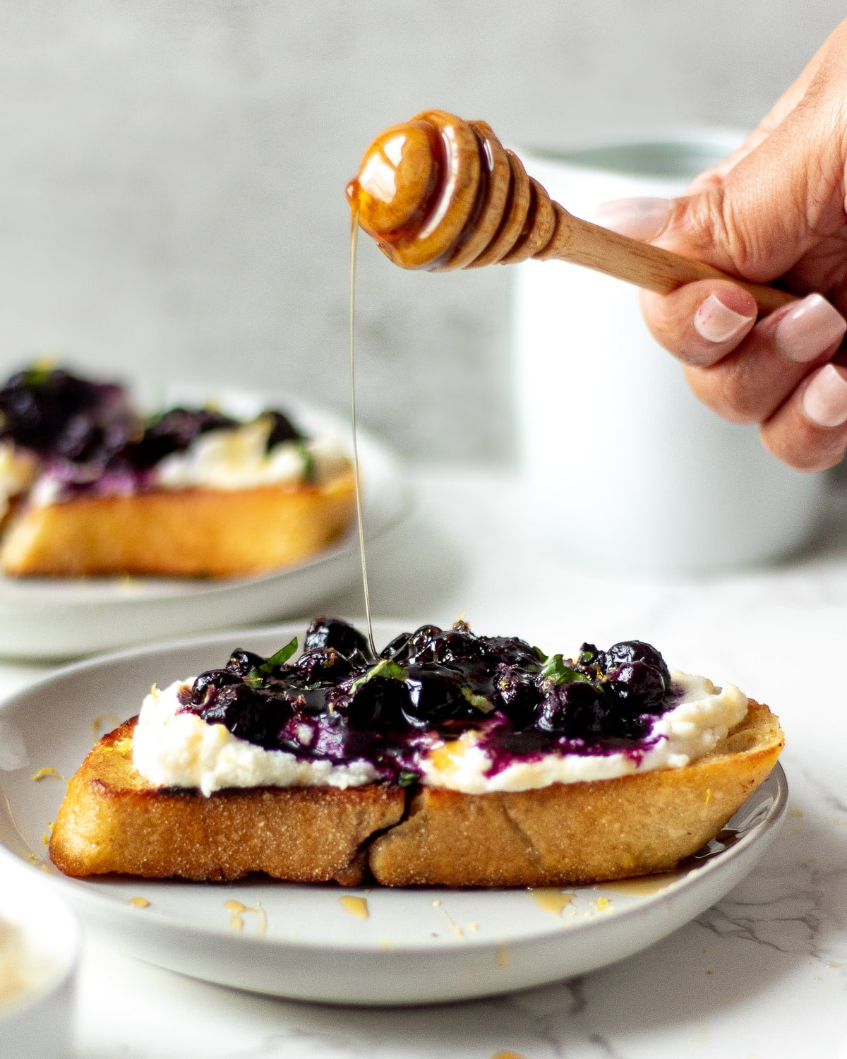 honey drizzling on blueberry ricotta toast