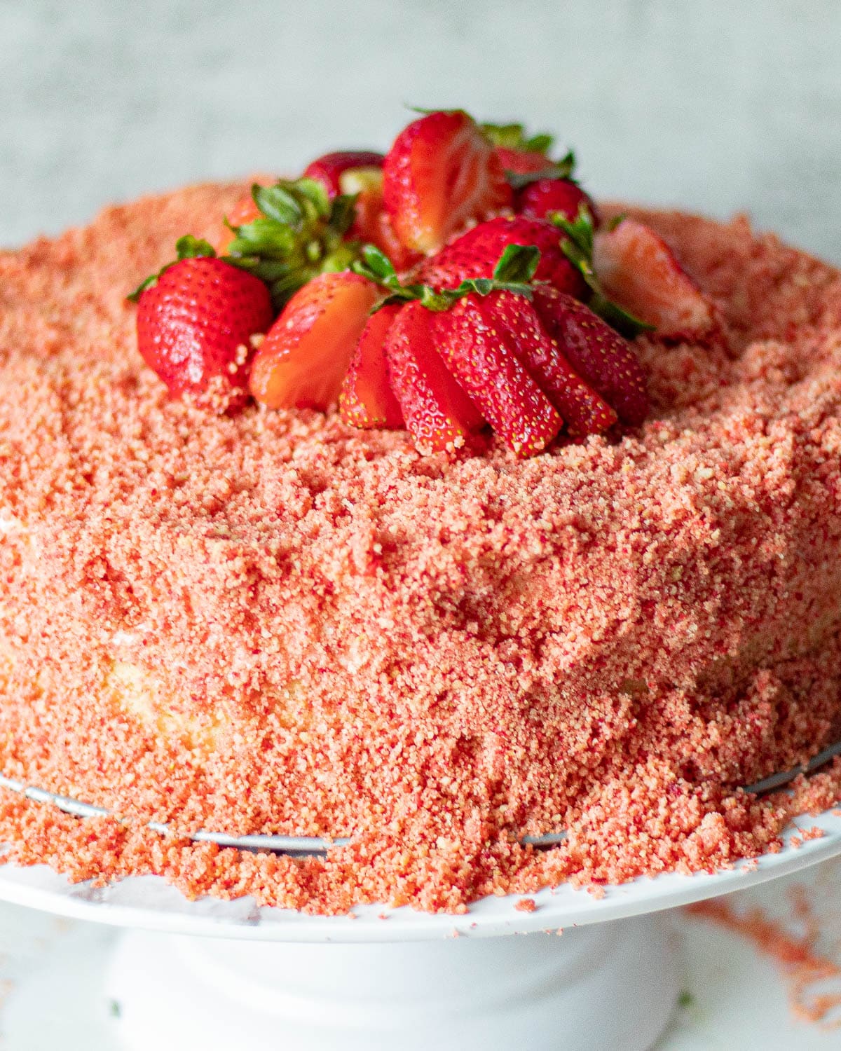 strawberry crunch cheesecake - no bake recipe on a cake stand