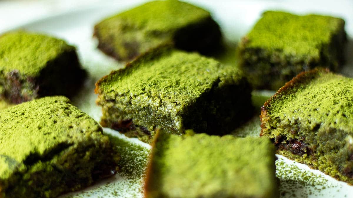 matcha brownies dusted with matcha powder on a plate