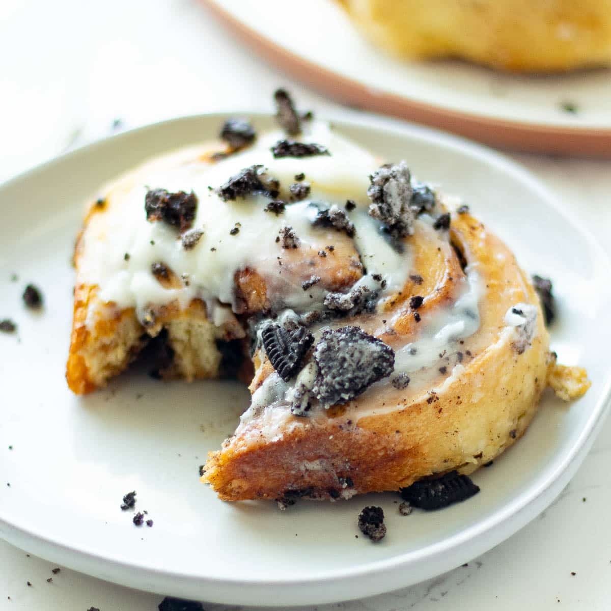 oreo cinnamon rolls on plates with a bite taken out