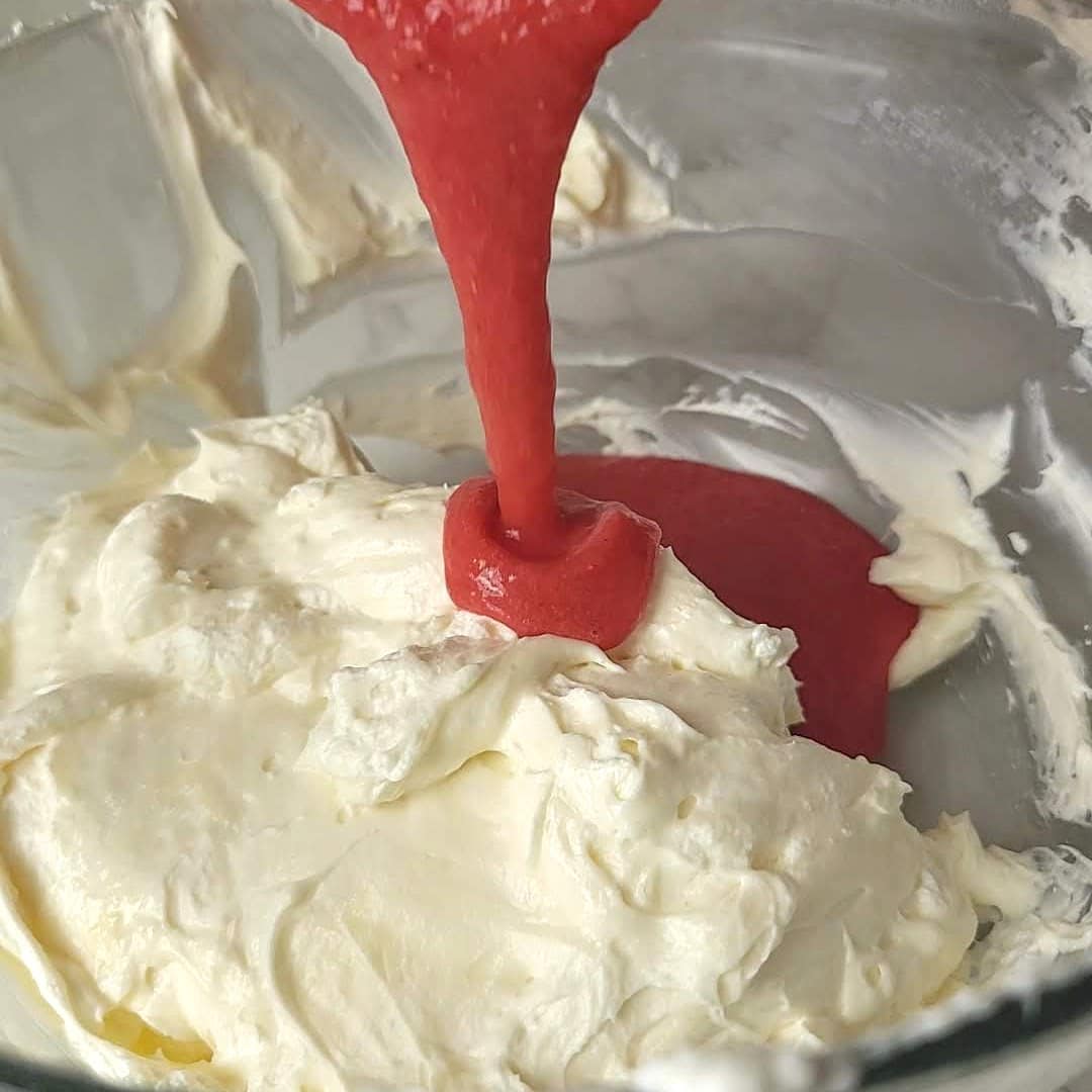 adding strawberry puree to cheesecake mixture