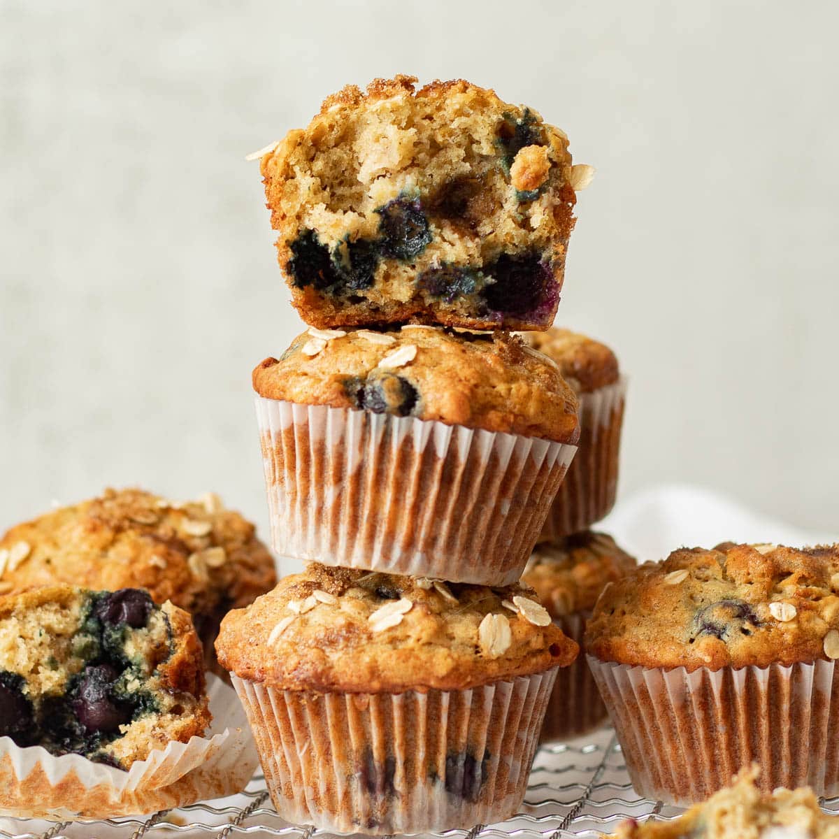 banana blueberry oatmeal muffins stacked on a rack
