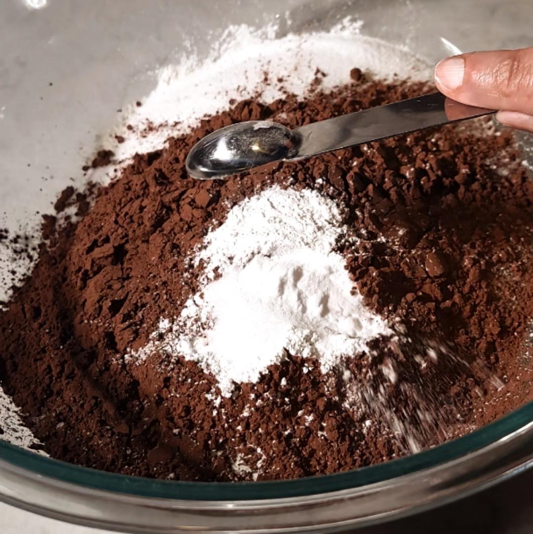 A blend of dry ingredients with cocoa powder and flour being prepared for Matilda's Chocolate Cake recipe.