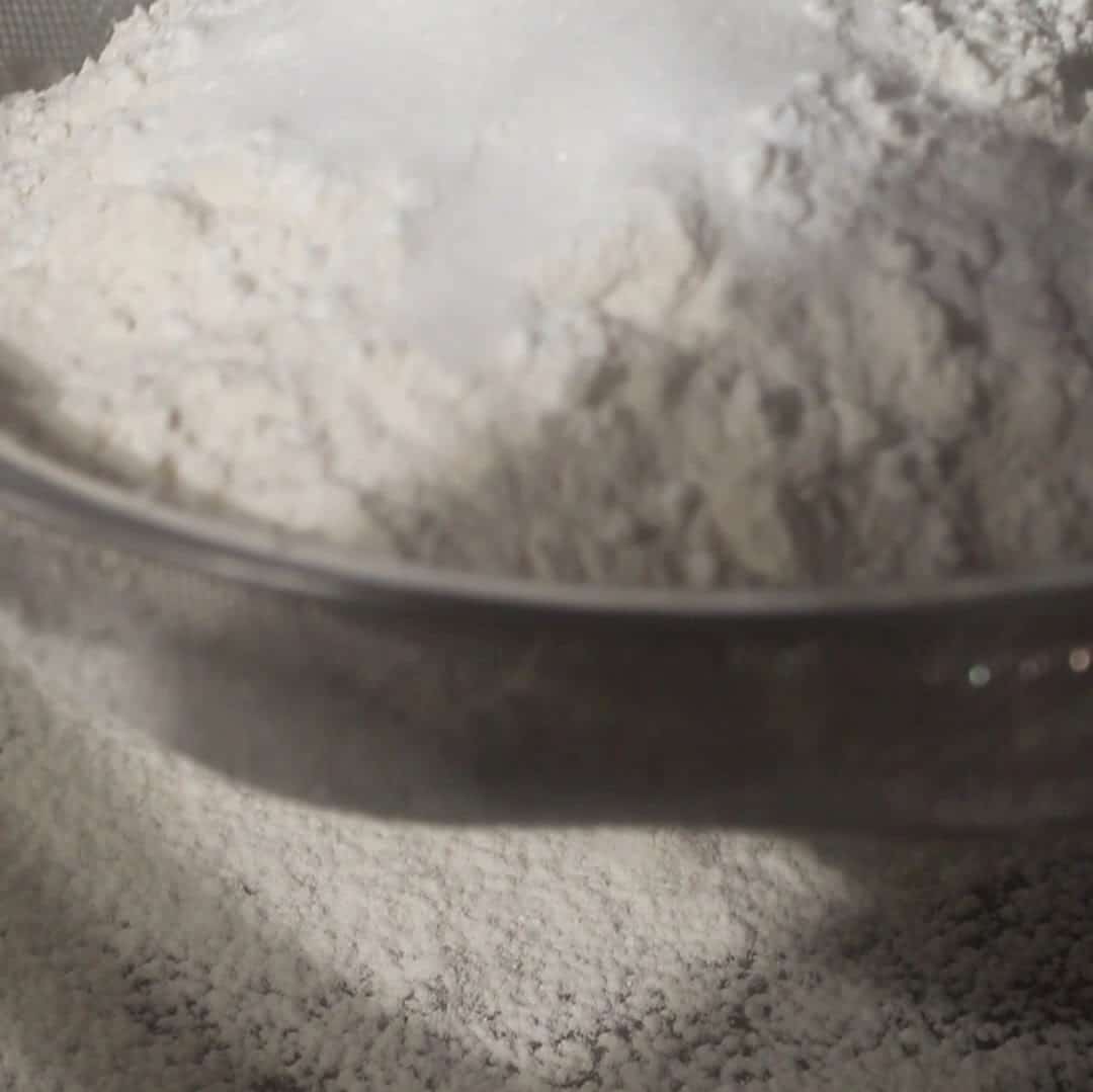 Flour mixture being sifted together to prepare dough for kitchen sink cookies.