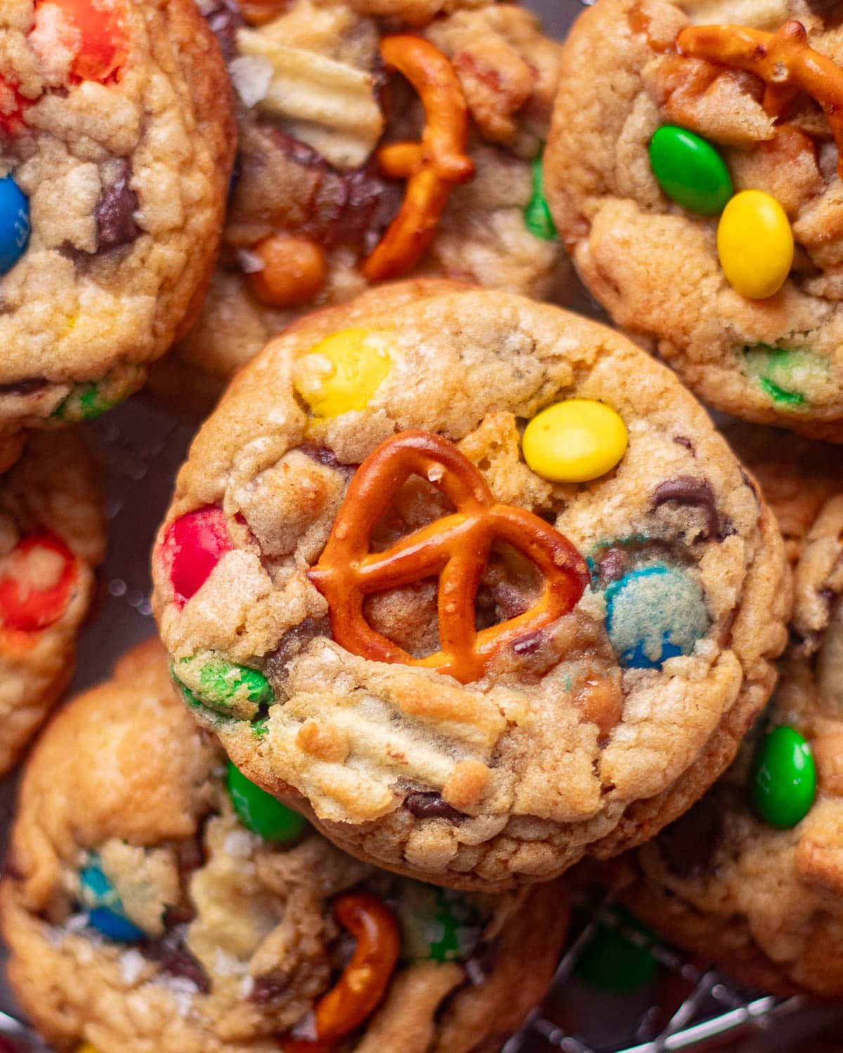 Close-up of thick and chewy Panera-style kitchen sink cookies with crunchy pretzels, M&Ms, and rich chocolate chunks.