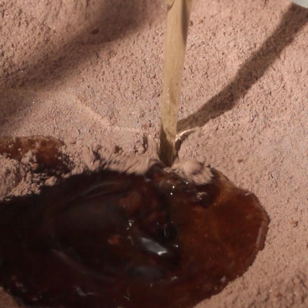 Pouring vegetable oil into dry ingredients for chocolate mousse cake.