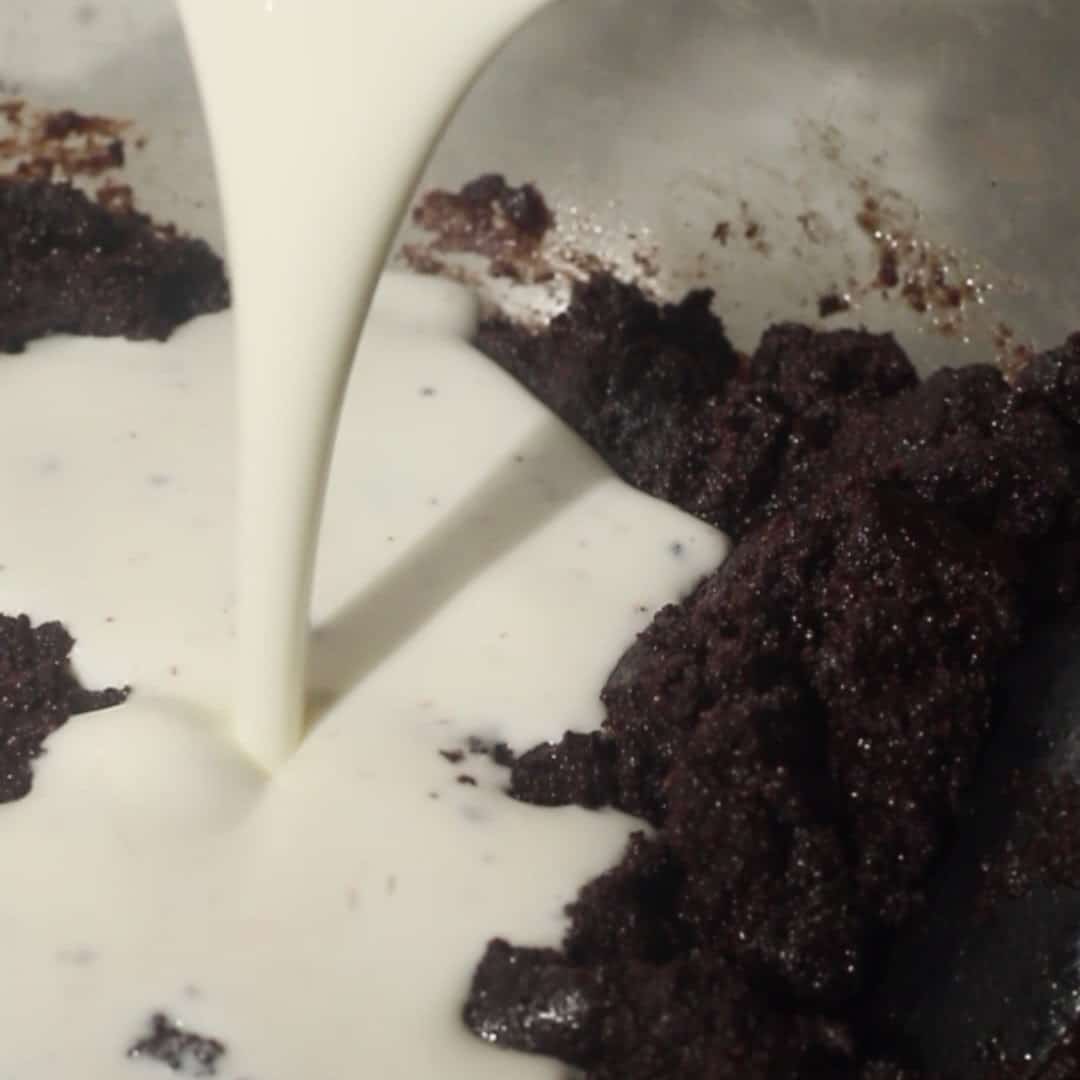 Pouring buttermilk into chocolate mousse cake batter.
