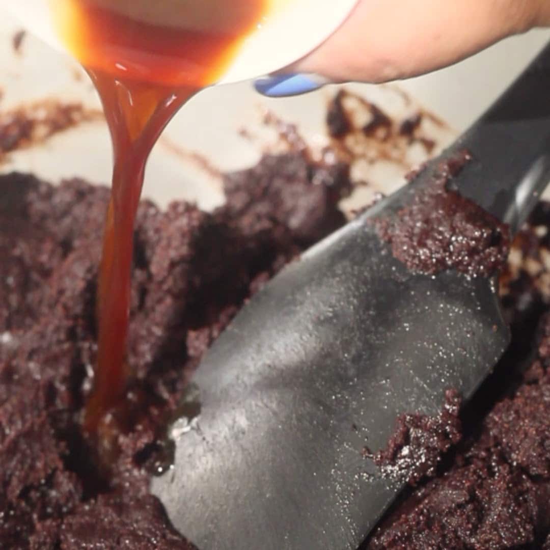 Pouring vanilla into the cake batter to enhance the flavor of the chocolate mousse cake.