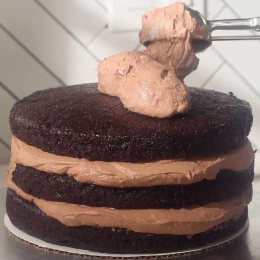 Layering thick chocolate mousse filling between moist chocolate cake layers.