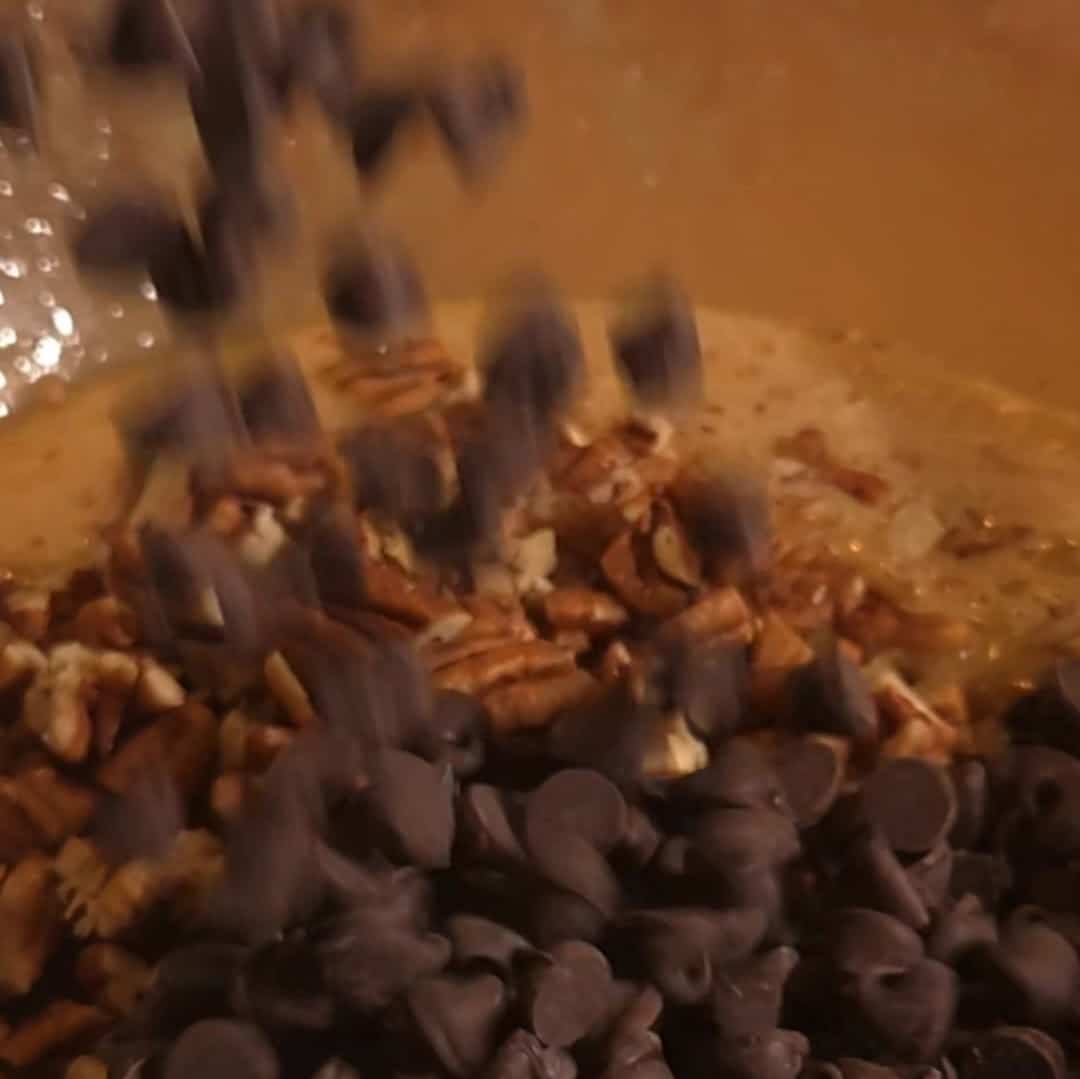 Adding chocolate chips and chopped pecans into the pecan pie filling for chocolate chip pecan pie.
