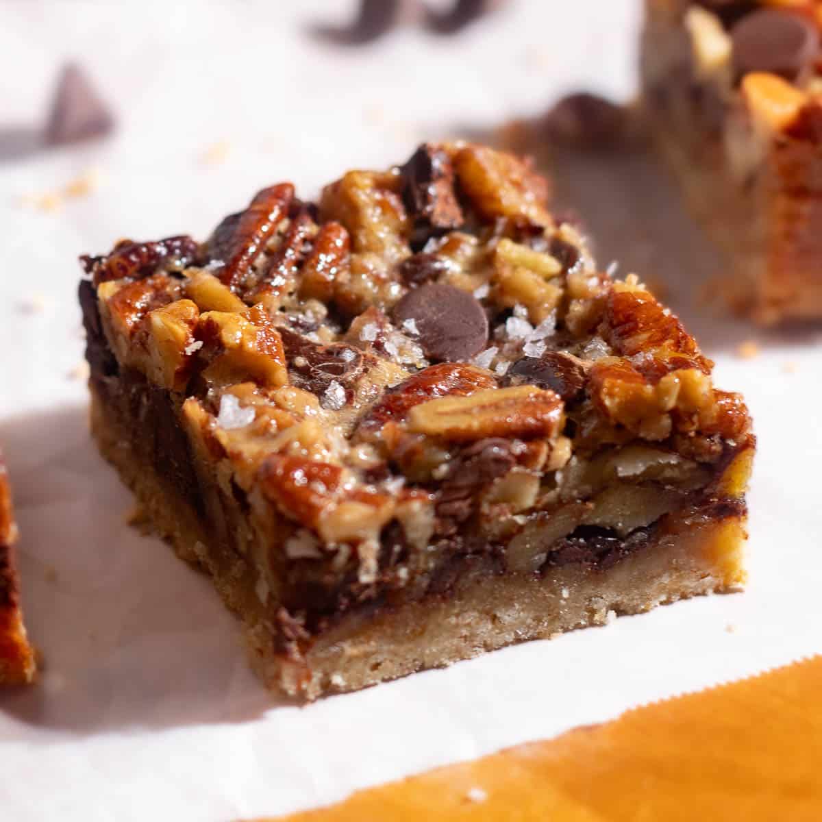 Close-up of pecan chocolate bars showing caramelized pecans and chocolate chunks baked into a golden crust.