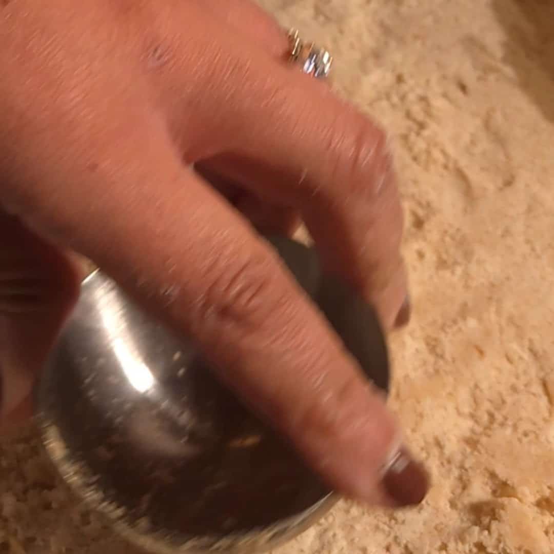 Chopping pecans on a wooden cutting board for the pecan pie filling.