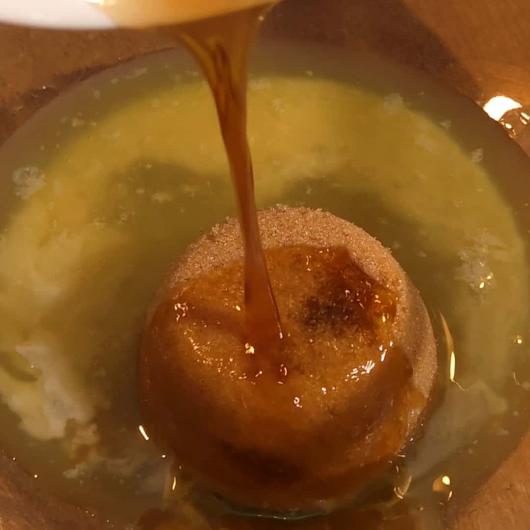 Pouring vanilla into the pecan filling mixture for chocolate pecan pie bars.