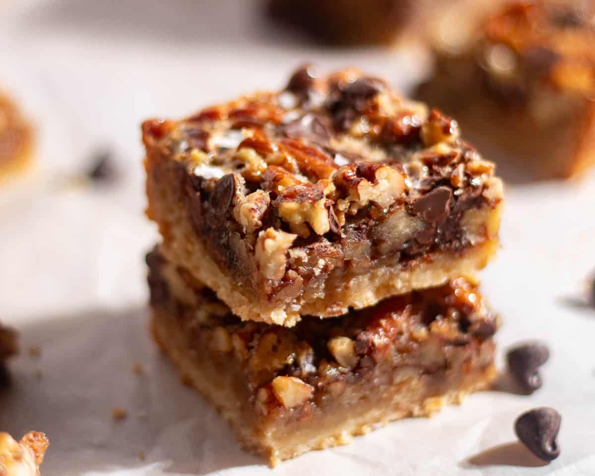 Close-up of pecan chocolate bars showing caramelized pecans and chocolate chunks baked into a golden crust.