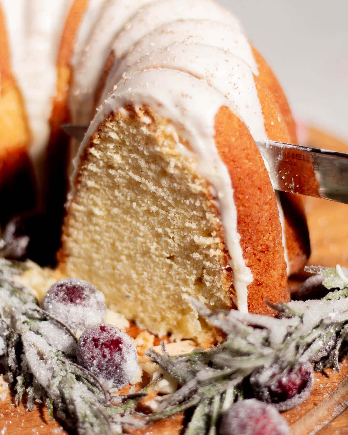 Sliced eggnog pound cake showing soft, buttery texture topped with smooth eggnog glaze and dusted with nutmeg.