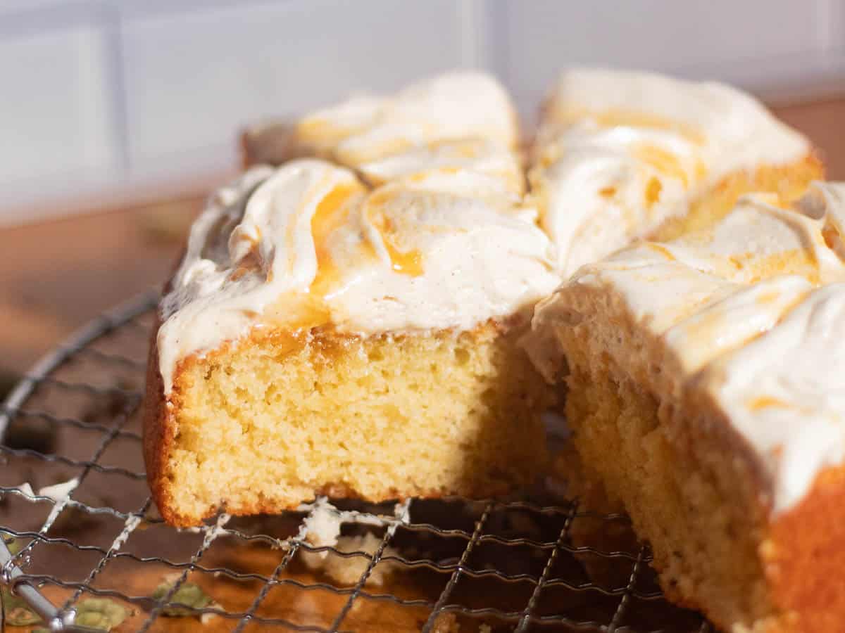 Brown butter cream cheese frosting spread on cake slices with smooth creamy texture and visible brown butter speckles.